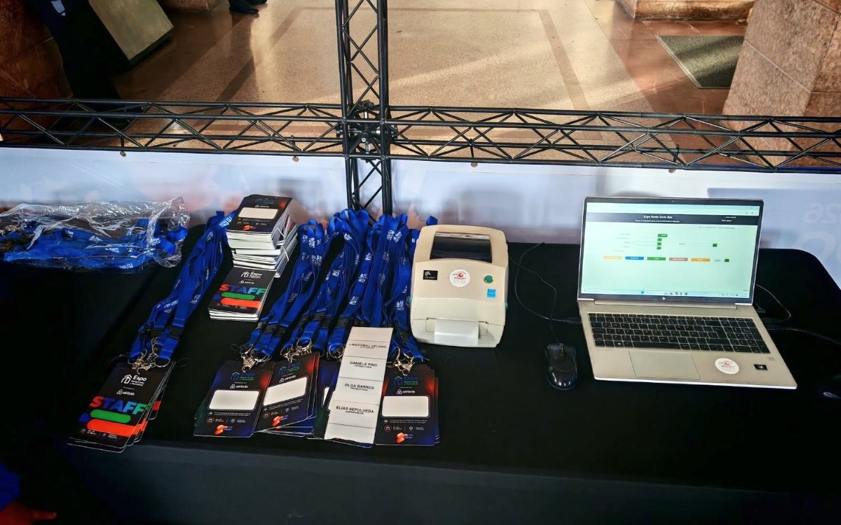 Impresora de credenciales, credenciales y notebook en un punto de acreditación