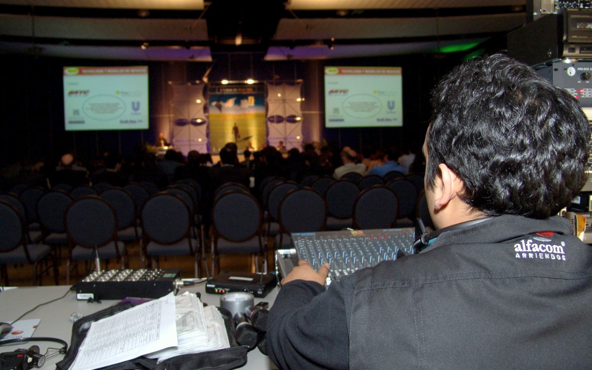 Técnico de Alfacom operando la consola de audio en un evento