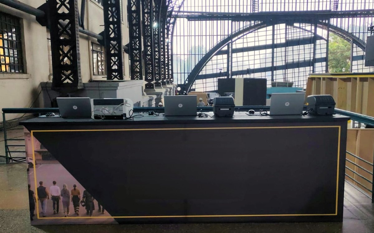 Computadores e impresoras instalados en un mesón de feria